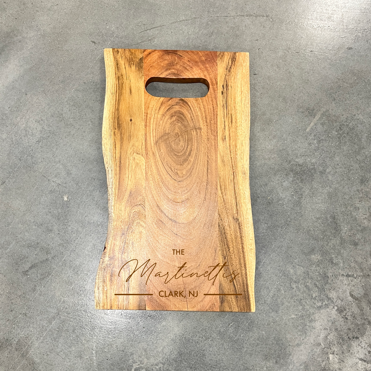 Live edge serving board with center hole family name engraving
